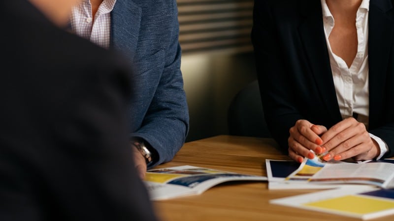 Karriere 12 Damen im Business-Outfit sitzen an Bewerbungstisch