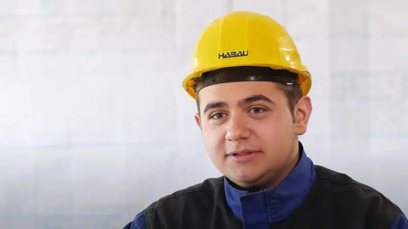 Portrait of a young man wearing a construction helmet and work clothes