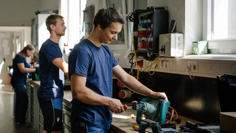 Three apprentices at work in a workshop