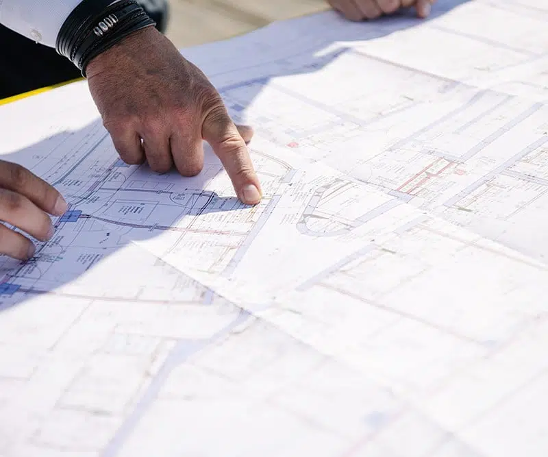 Hands point to a construction plan